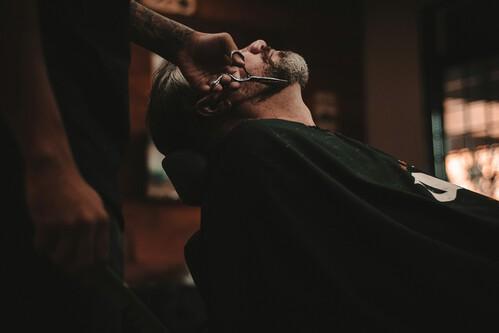 Barbeiro atendendo um cliente durante o corte